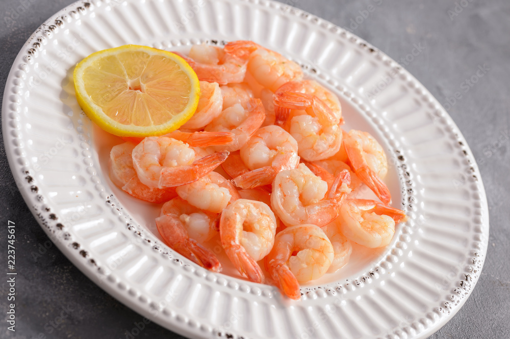 Cooked shrimps on the white plate with lemon.