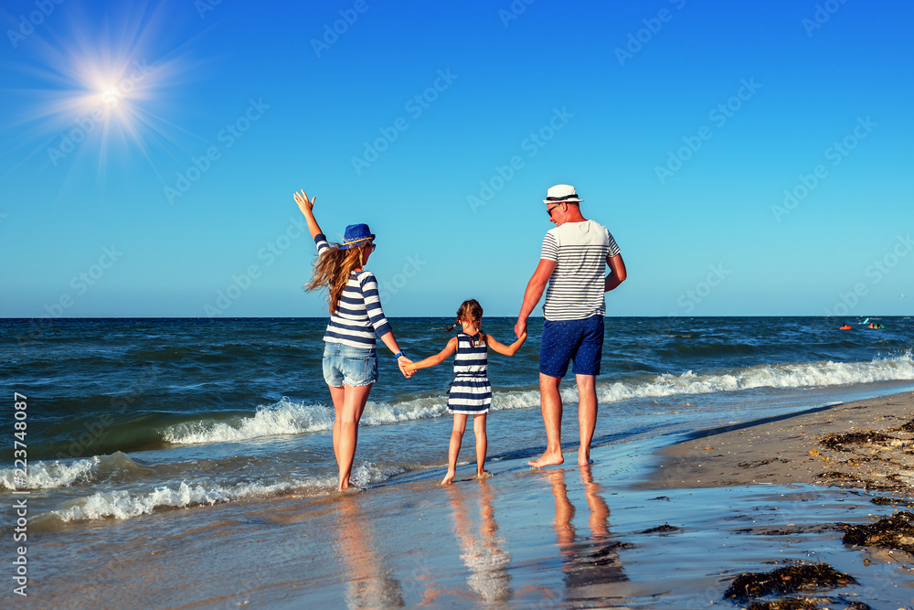 young family on the sea shore - obrazy, fototapety, plakaty 