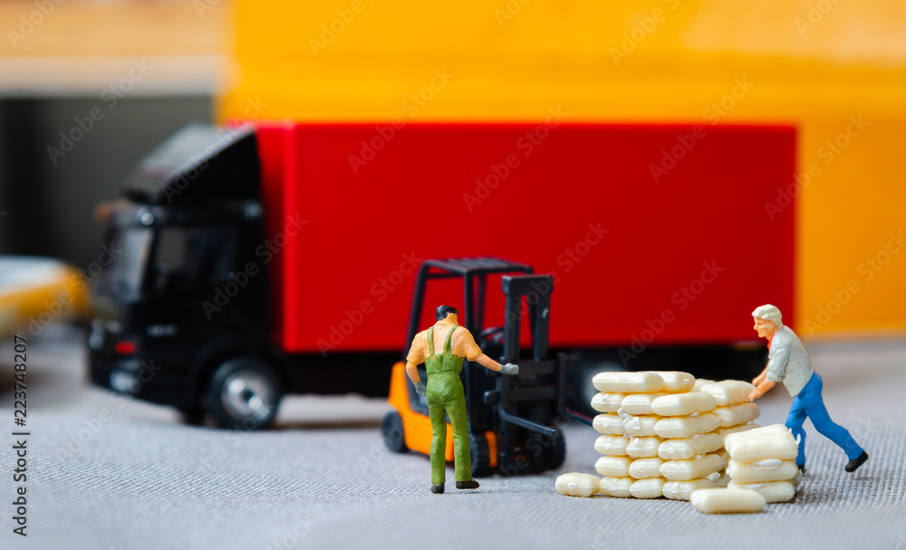 miniature figures warehouse workers forklift carrying sacks to semi truck with trailer .logistics warehouse freight transportation concept