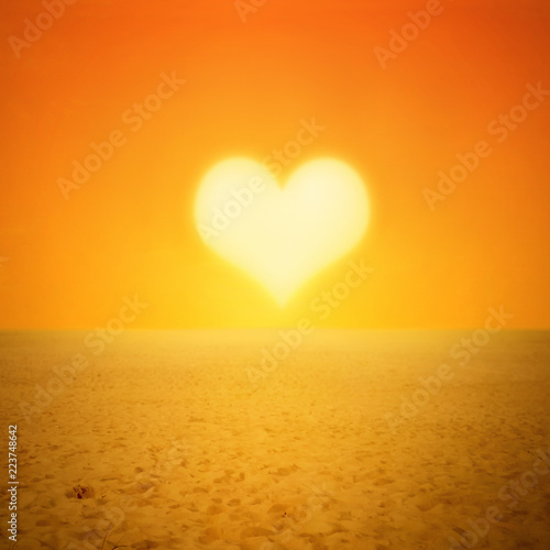 Sunset sun heart shape in desert or beach landscape with footprints