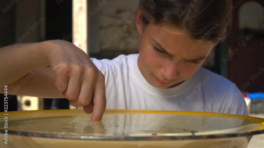 Boy teen plays in the basin with water slow motion. A sad child moves his finger along the surface of the water, slow-motion shooting.
Boy teen plays in the basin with water slow motion. A sad child moves his finger along the surface of the water, slow-motion shooting.