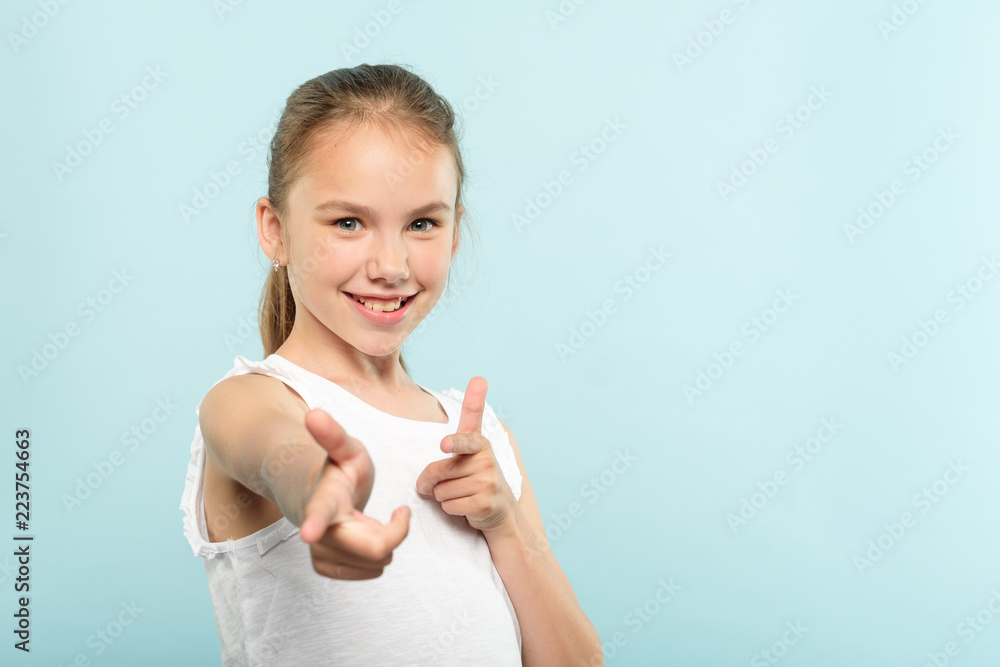 you rock girl. success and approval concept. confident smiling child looking at viewer and pointing index fingers. kid portrait on blue background. you rock girl. success and approval concept. confident smiling child looking at viewer and pointing index fingers. kid portrait on blue background.