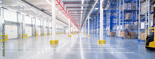 Huge distribution warehouse with high shelves and loading gates.