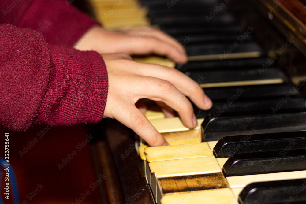 Fototapeta premium little hands playing an old piano