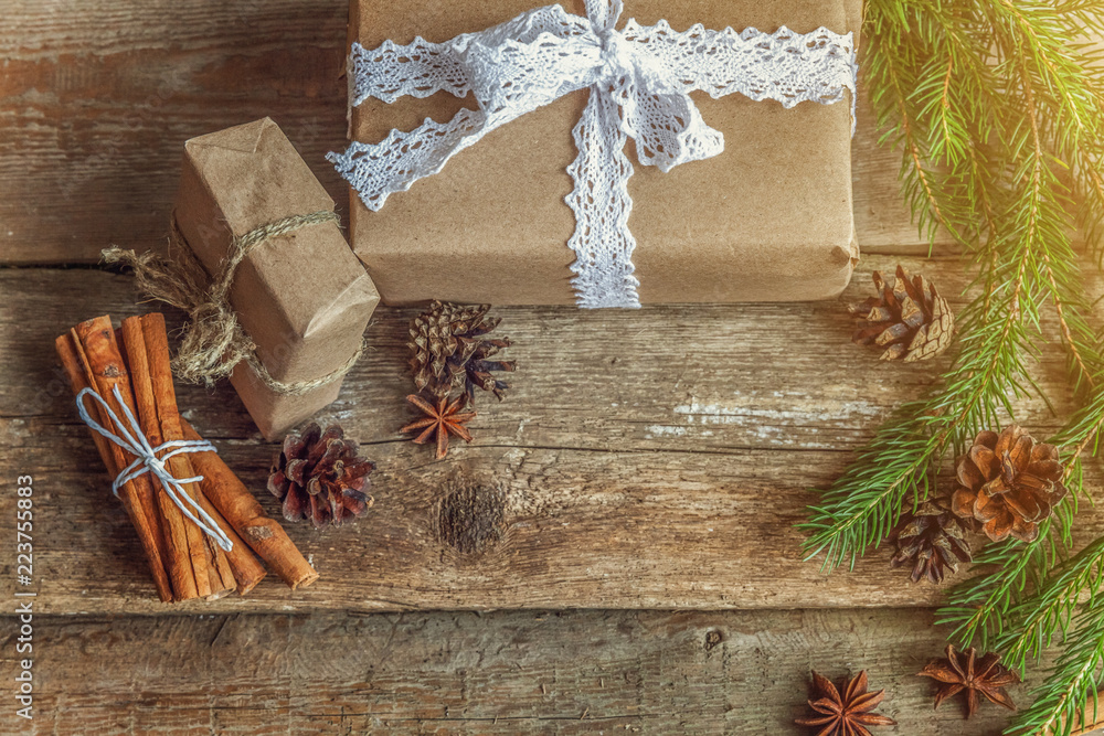 Obraz premium Christmas New Year composition with gift box fir branch pine cones cinnamon sticks on old shabby rustic wooden background. Xmas holiday december decoration to Russian tradition. Flat lay, copy space