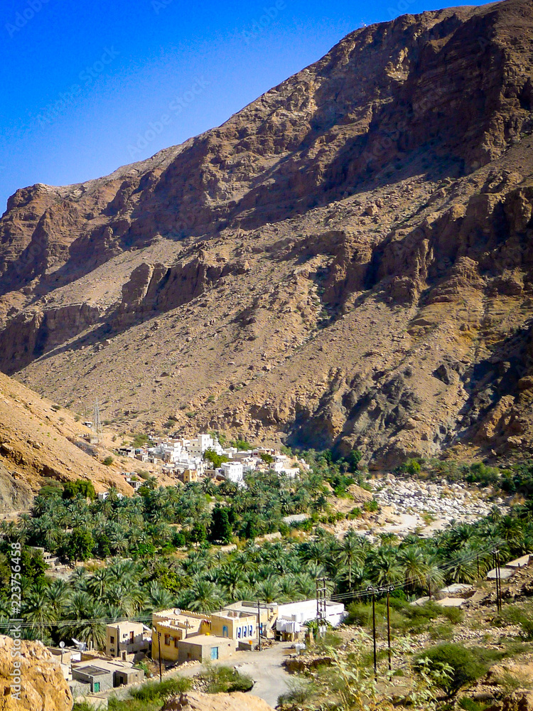 View of small village and mountain side, inside Wadi Tiwi, near Muscat in Oman