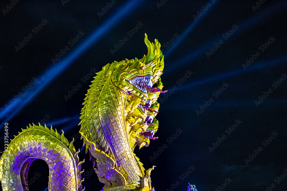Naga Fireball Festival in Nong Khai, Thailand. Giant Naga statue with spotlights in the air behind.