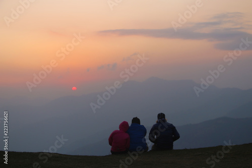 Group of people watching a sunset from mountain