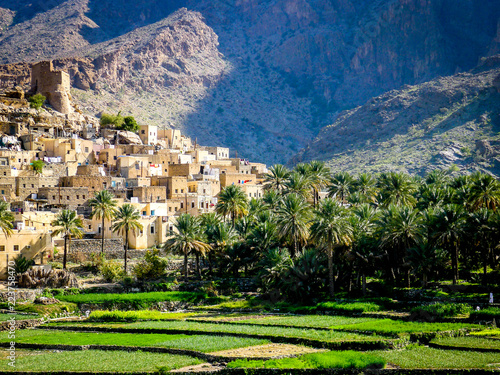 The beautiful mountain village of Balad Sayt sits in front of green fields in Wadi Bani Awf, Oman photo