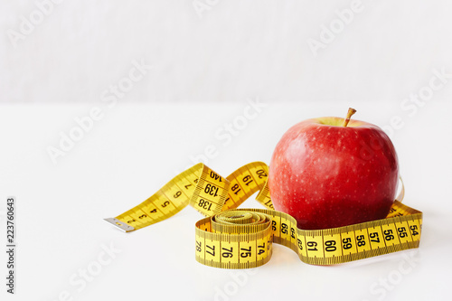 Measure tape and fresh fruit apple on white background. Loss weight, slim body, healthy diet concept