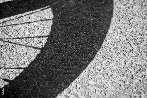 Shadow from a bicycle wheel on the asphalt
