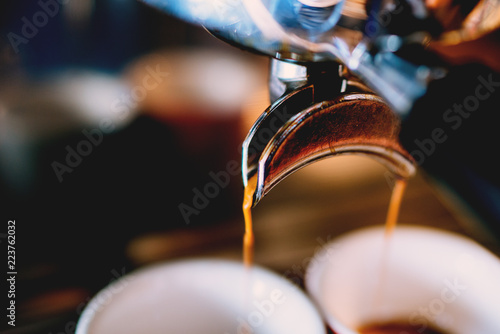 Professional coffee brewing -espresso coffee pouring from espresso machine close up