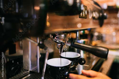Professional espresso machine preparing fresh espresso in two cups in bistro or restaurant