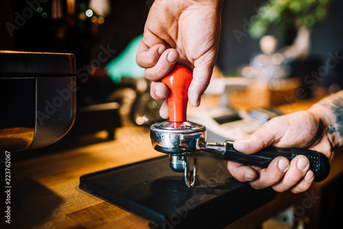 Professional barista using tamper and pouring freshly brewed coffee in cafe shop. barista details and bartender.