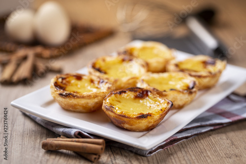 Typical Portuguese custard pies - "Pastel de Nata" or "Pastel de Belem". traditional portuguese pastry. On a wooden table.