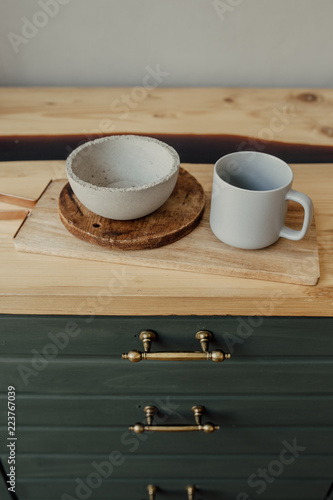 Empty grey cup and plate on old wooden. Green kitchen