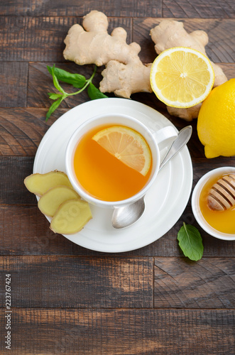 Ginger root tea with lemon and honey on wooden background, top view, copy space.