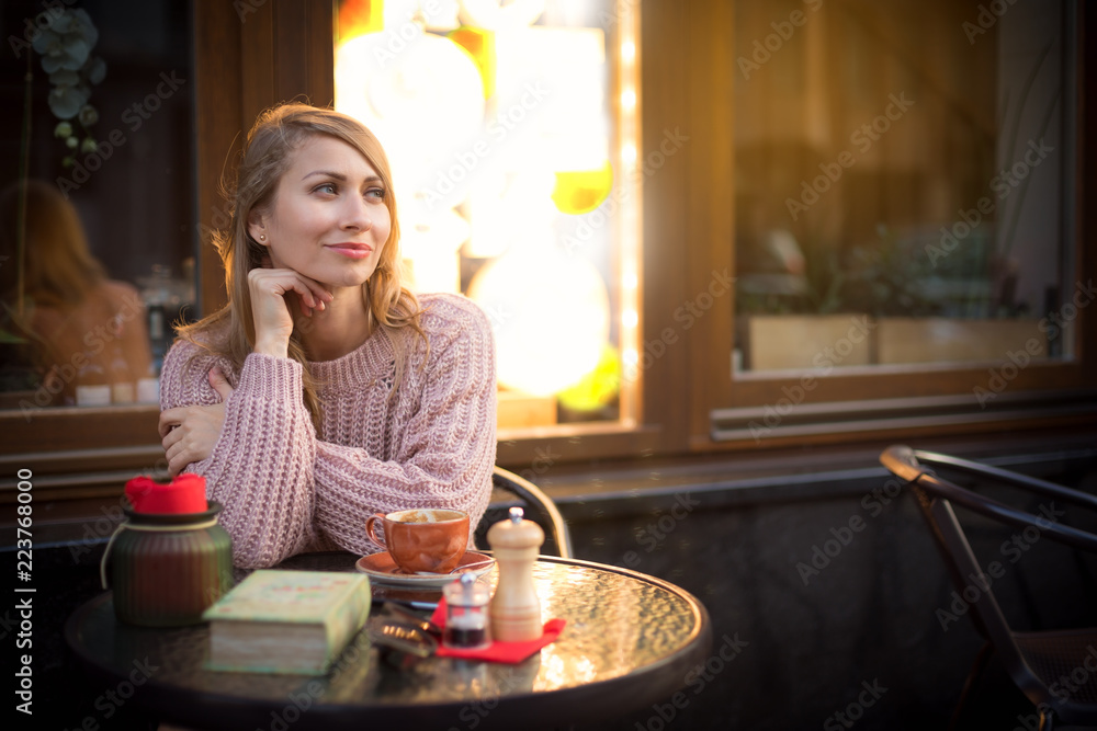 Woman drinks coffee outside of cafe Woman drinks coffee outside of cafe