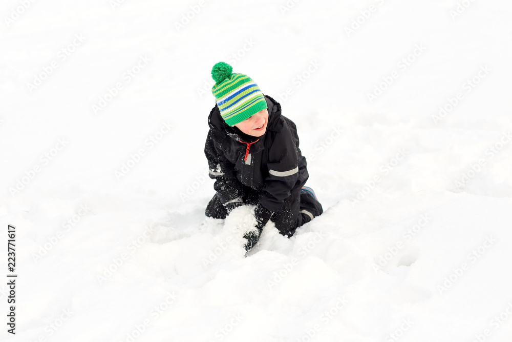 childhood, leisure and season concept - happy little boy playing with snow in winter childhood, leisure and season concept - happy little boy playing with snow in winter