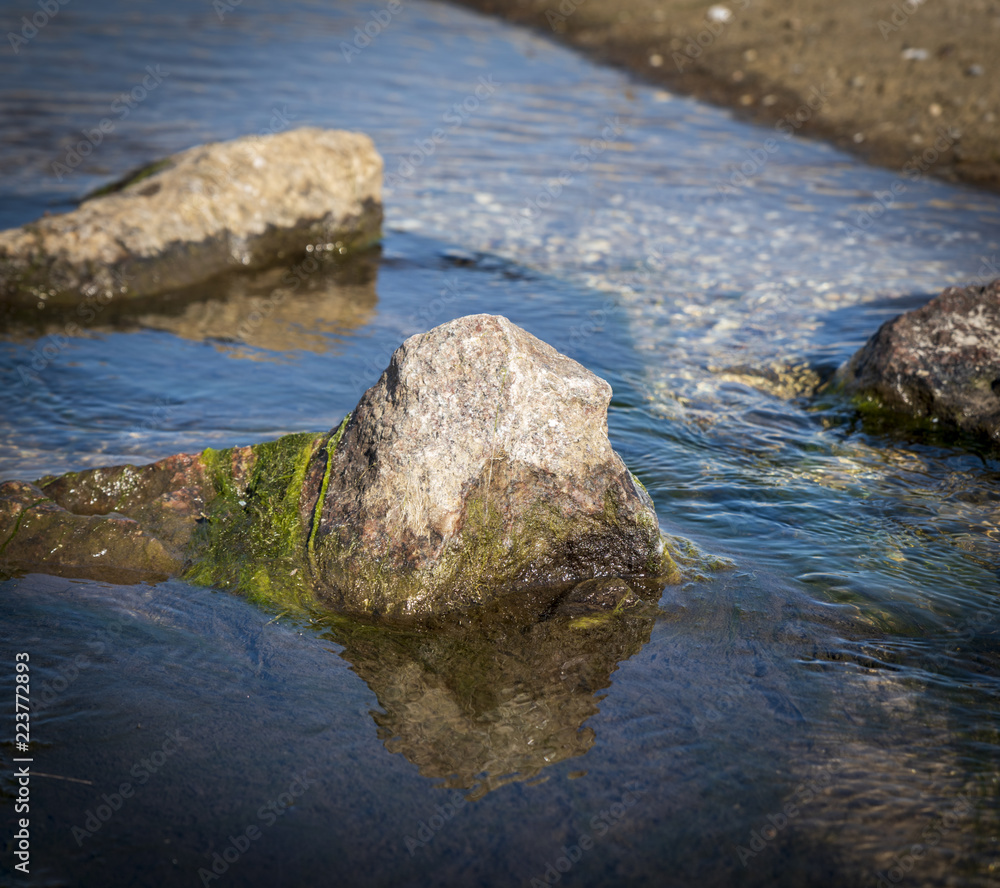 stone sticking out of the sea water summer day stone sticking out of the sea water summer day