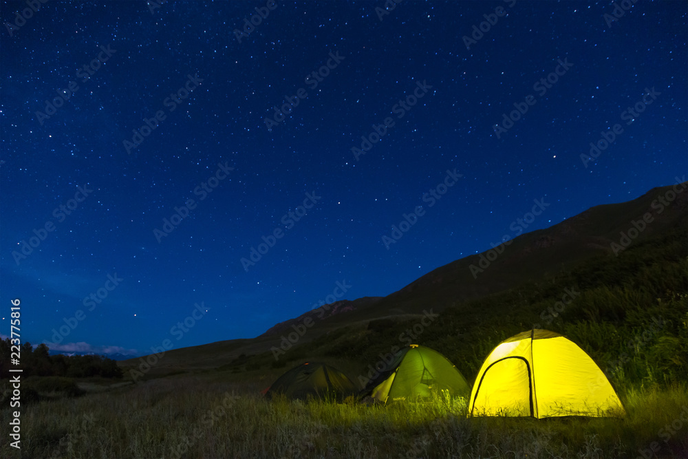 Night camping. Light in tents. The starry sky.