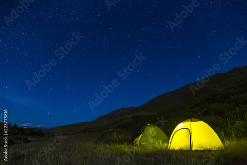 Night camping. Light in tents. The starry sky.