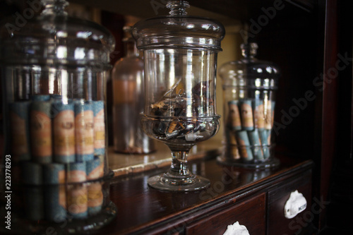 Old pharmacy, showcase. Vials and antique bottles with different substances, medicines or liquids on shelf photo