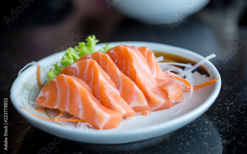 Fresh salmon slice and japanese on dish by lettuce and radish. Clean and fresh food for healthy concept.