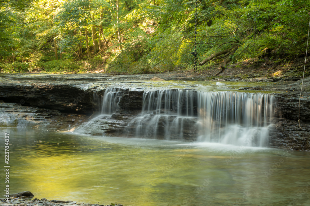 Fototapeta premium Waterfall on small creek in late summer
