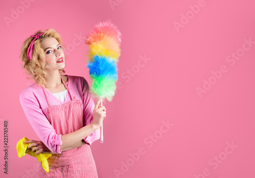 Hygiene concept. Happy girl hold colorful duster brush and rag. Cleaning service. Girl cleaner with feather duster, rag. Housewife with cleaning sweep.Woman from cleaning service with synthetic duster photo