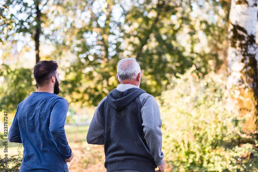 Happy father and son jogging together outdoors in park. Happy father and son jogging together outdoors in park.