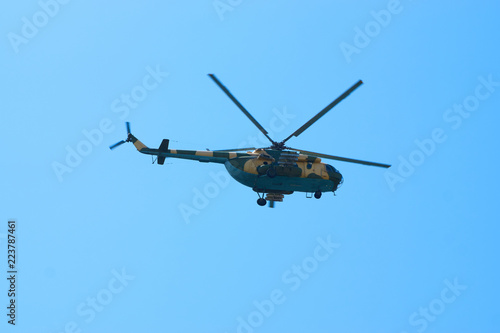 Military helicopters maneuvers in the blue sky. Group combat helicopters in flight during a military demonstration