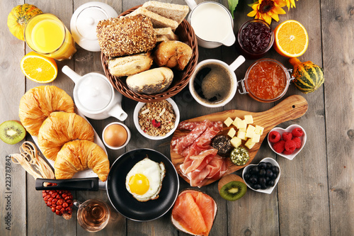 breakfast on table with bread buns, croissants, coffe and juice.