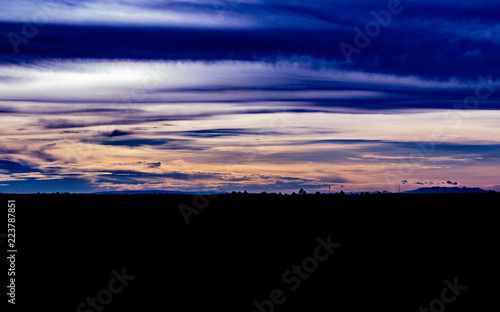 Obraz na płótnie A beautiful and colourful sunset in Bueng Kan City, Thailand showing the skyline of mountains, trees and spotted structures. w salonie
