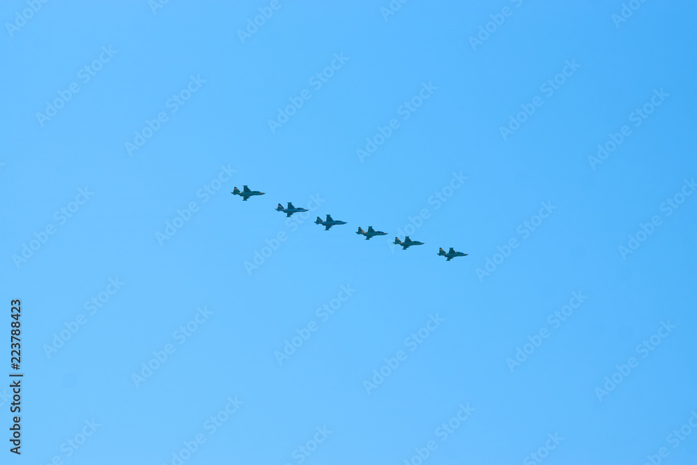 Modern military jet fighter airplanes flying in blue sky. Fighter jets fly together with colorful smoke Modern military jet fighter airplanes flying in blue sky. Fighter jets fly together with colorful smoke