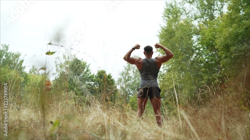 Obraz na plátně A handsome, hard-working man is standing in a field