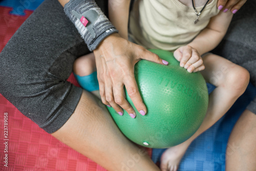 Little boy with cerebral palsy doing exercises with ball