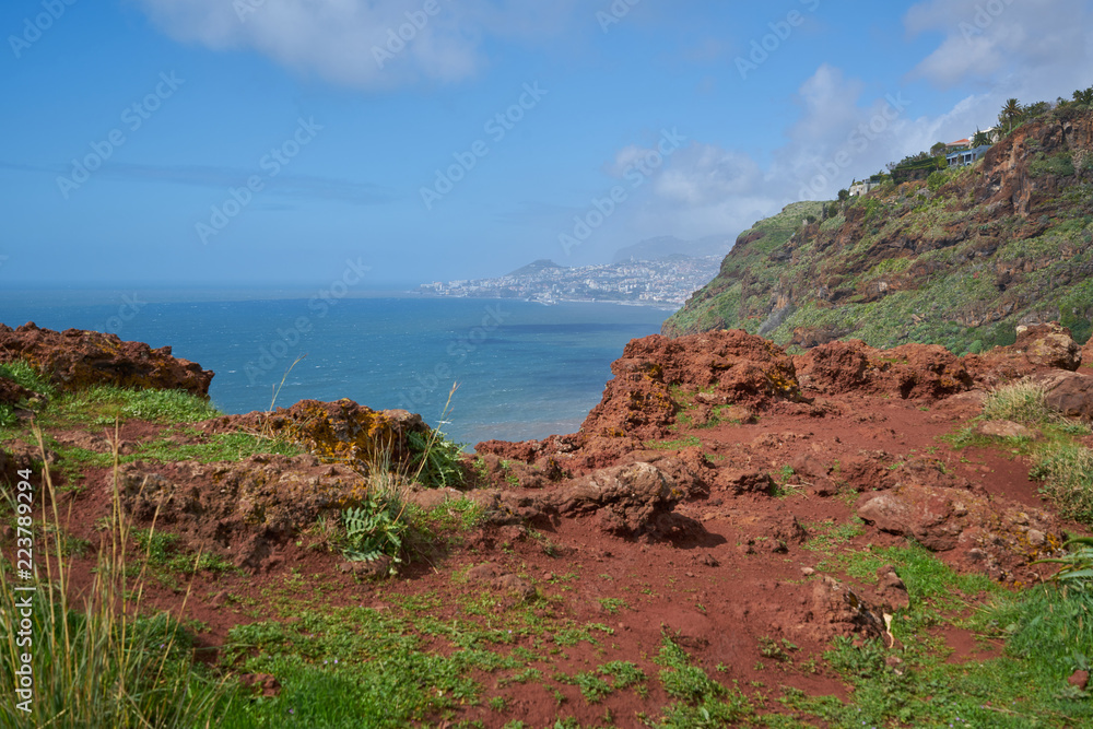 View of the coastline of Caniço, Madeira with Funchal city on the background
