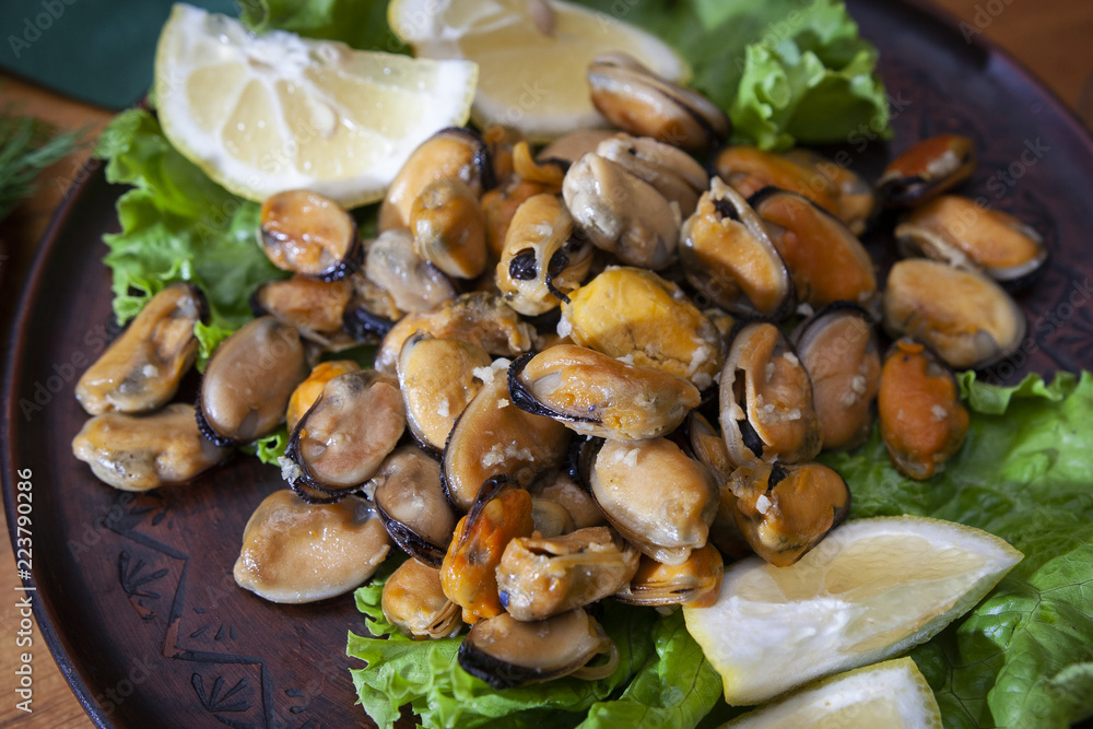 Closeup of green mussels and lemon in selective focus, top view of gourmet mussels Closeup of green mussels and lemon in selective focus, top view of gourmet mussels