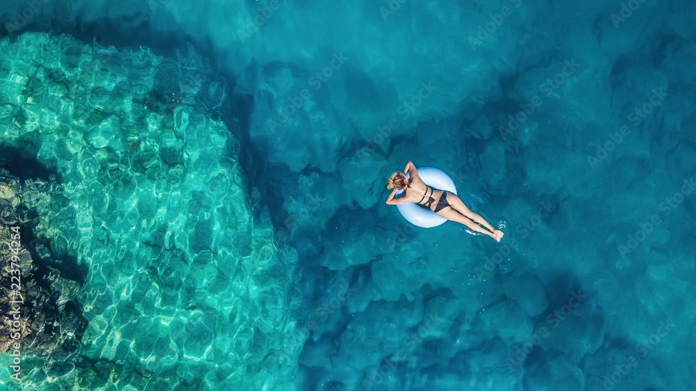 Aerial view at the girl on sea. Turquoise water from air as a background from air. Natural seascape at the summer time. Seascape from drone