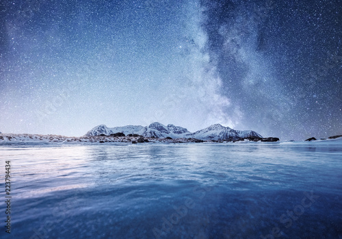 Fototapeta samoprzylepna Mountans i odbicie na powierzchni wody w nocy. Zatoka morska i góry w nocy. Droga Mleczna nad górami, Norwegia. Piękny naturalny krajobraz w Norwegii
