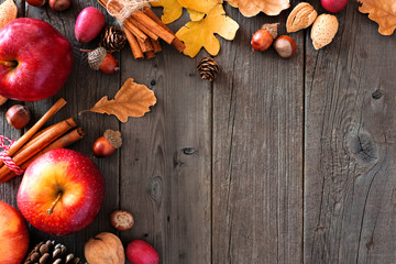 Autumn corner border of apples and fall ingredients on a rustic wood background with copy space