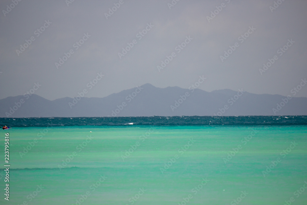 Shallow emerald waters with a mountain on the horizon at Phi Phi Island