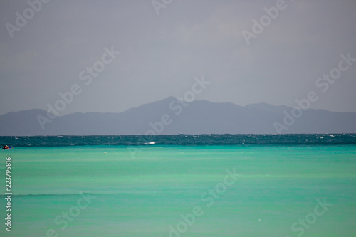 Shallow emerald waters with a mountain on the horizon at Phi Phi Island