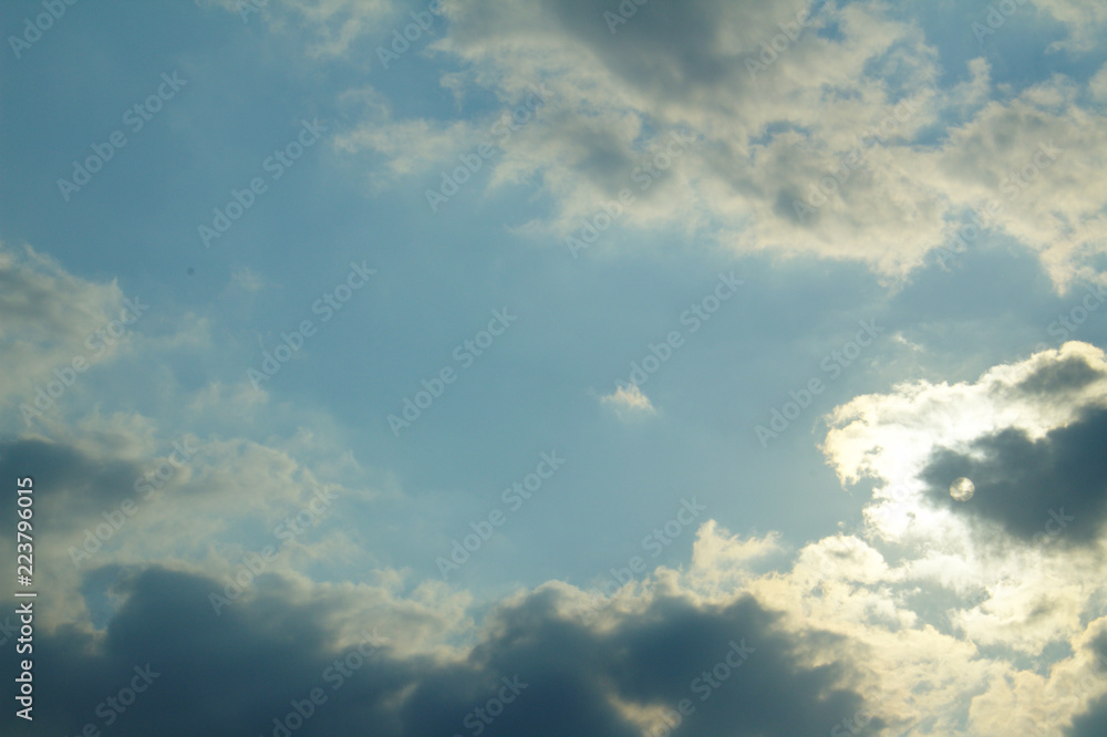 Bright Blue Sunlit Summer Sky Framed by Silver Lined Backlit Clouds