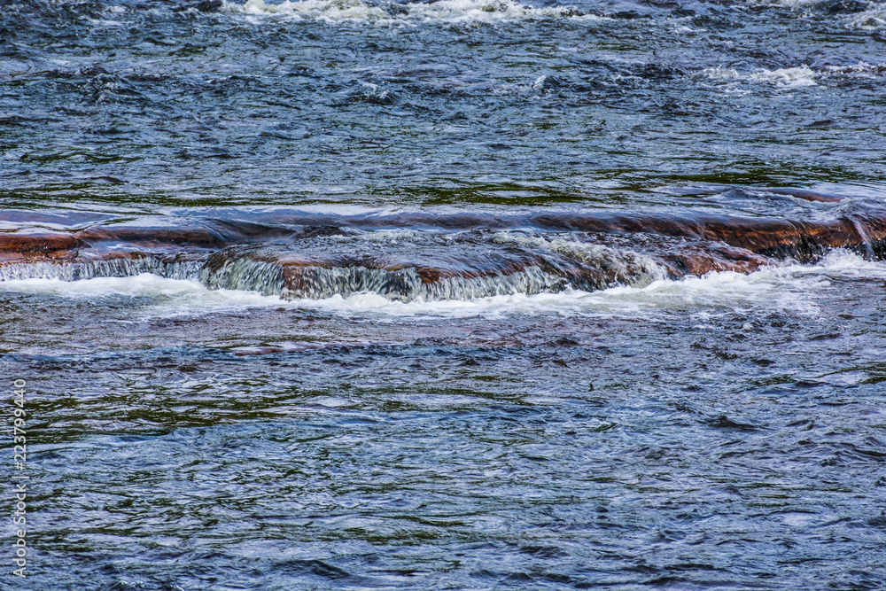 Obraz premium A river gently flowing over rocks