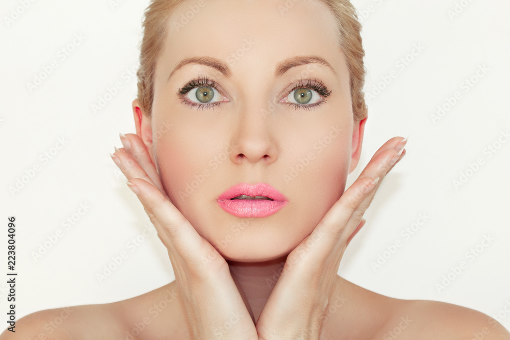 Portrait. Close-up of a beautiful young woman holding hands near the face. The concept of healthy and moisturized skin. With beautiful eyes.