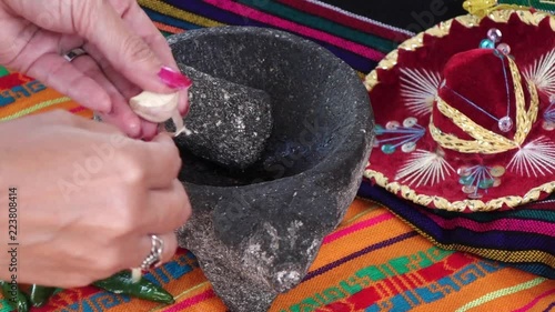 Cutting garllic in a traditional mexican way with molcajete