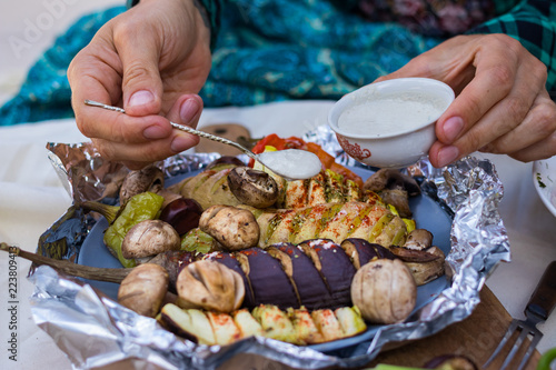 Baked, grilled, roasted vegetables in foil with tartar white sauce. Eggplants, mushrooms, red bell pepper, potato