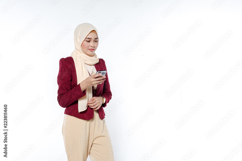 portrait of beautiful young Muslim woman using a mobile phone with a smile on a white background portrait of beautiful young Muslim woman using a mobile phone with a smile on a white background